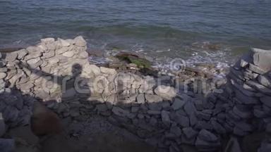灰色的岩石和石头被收集在海岸的边<strong>缘</strong>和即将到<strong>来</strong>的波浪